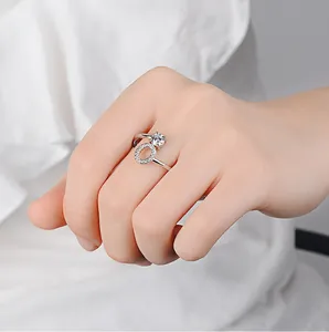 Détail d'une bague argentée avec pierre ronde et cercle pavé portée sur la main