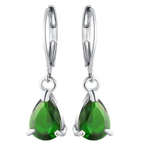 Macro detail of pear-shaped emerald drop earrings with silver lever-back clasps