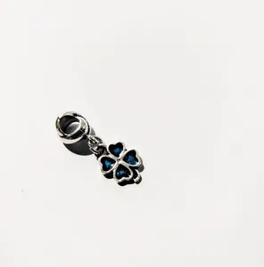 Detalle de dije de trébol de cuatro hojas con esmalte azul y aro colgante plateado