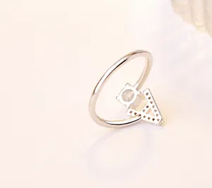 Détail macro d'une bague argentée avec lettre A en cristaux et finition polie
