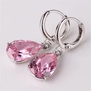 Detailed close-up of pink teardrop crystal earrings with silver-tone claw setting