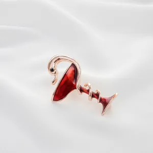 Detail of elegant swan and wine glass brooch with red enamel in rose gold plating