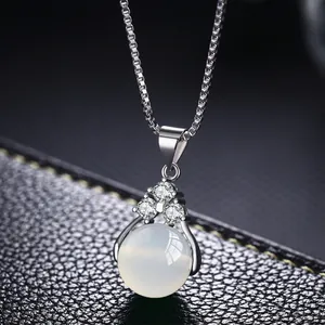 Detalle de collar de plata con colgante de opale lechoso y detalles de circonita