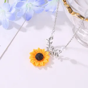 Détail du collier tournesol avec deux petites perles blanches et une fine chaîne argentée