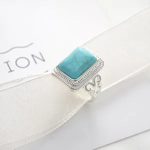 Detailed macro view of a vintage rectangle blue stone ring on a white textured ribbon
