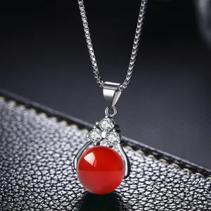 Primer plano de un colgante de gema roja con circonitas en una cadena plateada elegante