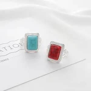 Detail of vintage bohemian silver rings with turquoise and ruby-red rectangular stones