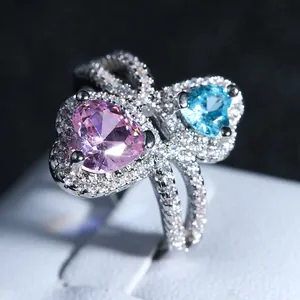 Elegant silver ring with interlocking heart-shaped pink and blue crystals and pavé diamonds