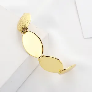 Detalle de un relicario dorado de cuatro páginas con grabado floral y marcos pulidos