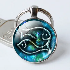 Llavero del signo Piscis en plata con cabujón de cristal y tótem de peces abstractos