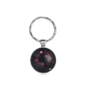 Llavero redondo plateado con colgante de cristal de nebulosa rosa con vista de cerca