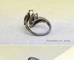 Detail van de gepersonaliseerde zwarte ring met paarse en amberkleurige kristallen