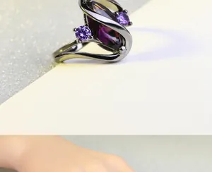 Detail van ring met marquise geslepen paarse edelsteen en zwarte coating