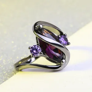 Ring met paarse marquise-edelsteen en zwart verguld metaal in een wervelontwerp