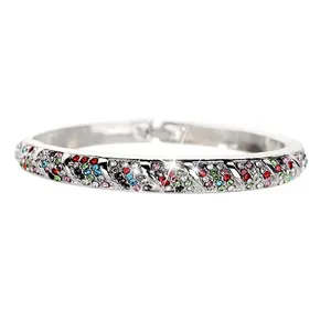 Macro detail of silver bangle featuring colorful crystals and textured edge patterns
