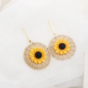 Sunflower woven earrings with yellow petals and round straw base on white mesh