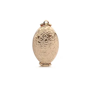 Colgante relicario ovalado de oro rosa vintage con grabado floral sobre fondo blanco