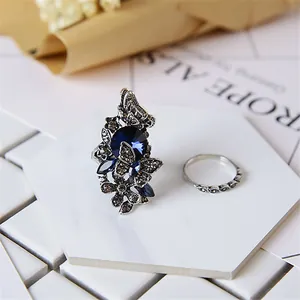 Vintage-Ring-Set mit blauem Kristall-Schmetterling und gedrehtem Silberband auf Marmor