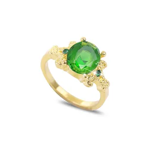 Bague vintage dorée avec une grande pierre précieuse verte ovale et cristaux