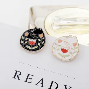 Detalle de los broches de esmalte de gatos blanco y negro con diseño de tulipán