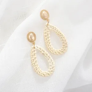 Bohemian gold metal stud earrings with beige teardrop woven rattan pendants