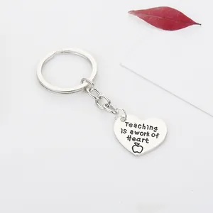 Macro detail of heart keychain with Teaching is a work of Heart engraving for teachers