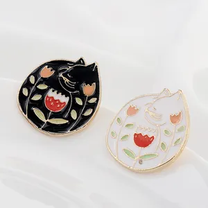 Broches de esmalte de gatos blanco y negro protegiendo tulipán con borde dorado