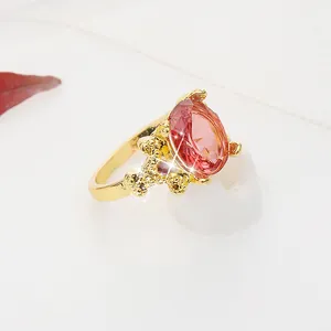 Vue macro d'une bague dorée avec une pierre rose ovale et des détails ciselés