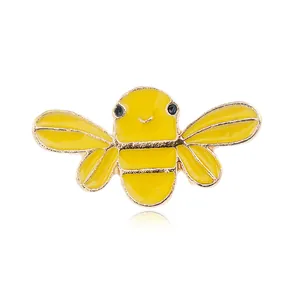 Vista macro de broche de abeja en esmalte amarillo con bordes dorados y acabado brillante
