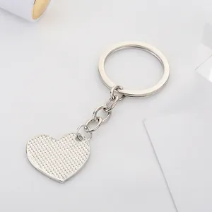 Macro shot of silver heart keychain with textured alloy surface and flat metal ring