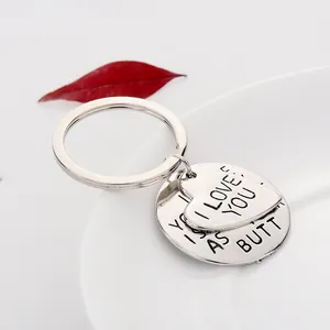 Detailed close-up of silver heart and round pendants with I LOVE YOU engraved lettering