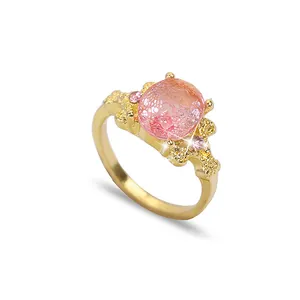 Bague dorée artistique avec une grande pierre rose et un anneau texturé style corail