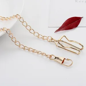 Detail shot of a minimalist gold chain accessory featuring a lobster clasp and specialty clip