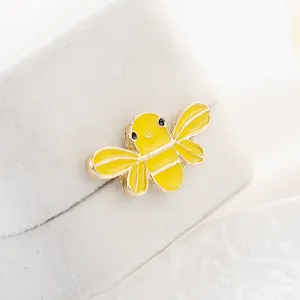 Vista macro de un lindo broche de abeja amarilla con baño de oro y esmalte artesanal
