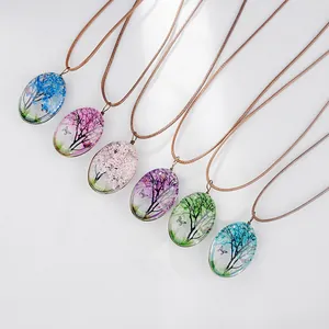 Détail de colliers ovales en verre avec paysages de paysages miniatures et papillons