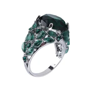 Macro view of silver ring featuring oval emerald gemstone and marquise side stones