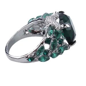 Macro shot of vintage style ring featuring a large oval emerald green gemstone and filigree