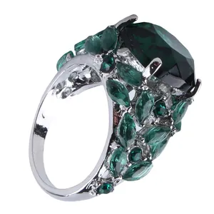 Macro view of emerald green marquise cut gemstone cluster ring with silver plating
