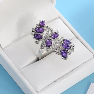Detailed side view of silver cocktail ring with oval purple stones and crystals