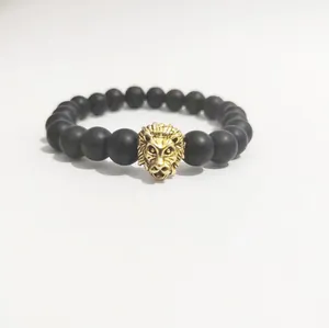 Pulsera para hombre con cuentas negras mate y un dije de cabeza de león dorado