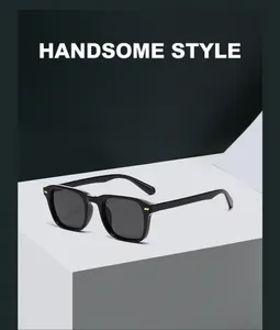 Close-up of black square frame sunglasses with gold accents on a minimalist stand