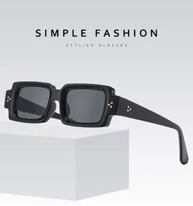 Detailed macro view of matte black rectangular sunglasses with stylish metal rivets