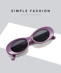 Detail shot of purple oval sunglasses with a retro minimalist frame and dark lenses