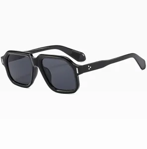 Detailansicht der dicken schwarzen quadratischen Sonnenbrille mit silbernen Dreipunkt-Nieten