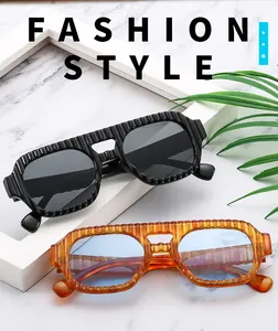 Détail de lunettes aviateur carrées avec monture texturée en noir et ambre élégant