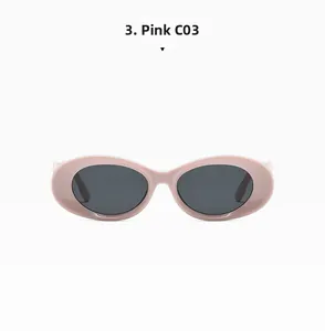 Detail view of pink oval frame sunglasses with thick edges and dark grey lenses