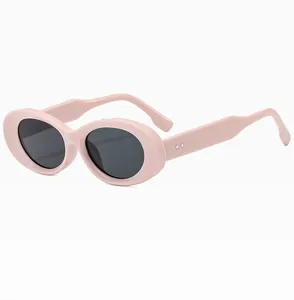 Close-up of nude pink oval sunglasses featuring silver diamond rivets on wide temples