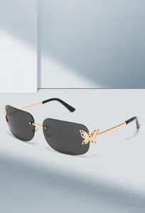 Detailed close-up of diamond-studded butterfly accent on rimless gold-temple sunglasses