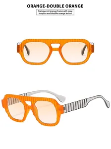 Détail de lunettes aviateur orange avec monture rayée et verres dégradés chic