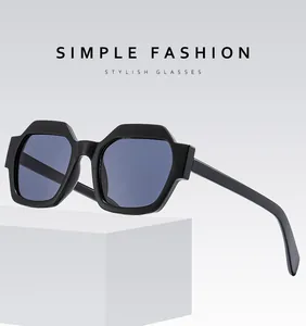 Detail of polygon sunglasses with blue lenses on a white geometric display stand